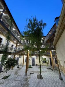 a courtyard with a tree in the middle of a building at Arba Hotel in Samarkand