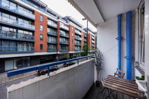 a balcony with a bench and a building with blue pipes at Trendy four bed flat in islington in London