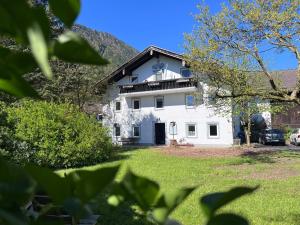 a white house with a balcony on a yard at Der Erberbauer in Piding