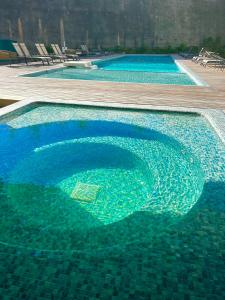 a large pool of blue water with chairs in it at Departameto de Lujo cerca de Mall Andares in Guadalajara