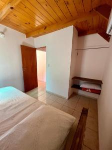 1 dormitorio con cama y techo de madera en Cabanas MERALE Excelente Ubicacion en Puerto Iguazú