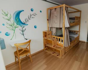 a room with a bunk bed and a chair at Araucária Hostel in São Bento do Sul