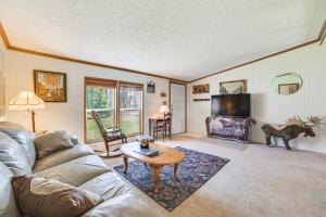 uma sala de estar com um sofá e uma mesa em Peaceful Lakefront Home with Deck in West Branch! em West Branch
