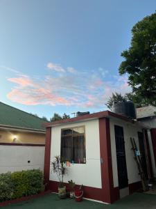 a red and white house with a cloudy sky at Bomani House in Arusha