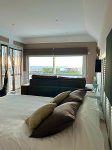 a bedroom with a large bed with pillows on it at Le Sterenn in Saint-Guénolé