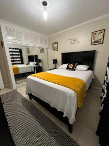 a bedroom with a large bed with a yellow blanket at The Brompton's Luxury Apartment in Kingston