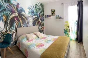 Schlafzimmer mit einem Bett und einem Wandbild von Palmen in der Unterkunft Magnifique villa avec piscine à 20 min de hossegor in Saint-Geours-de-Maremne