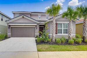 a house with palm trees in front of a driveway at Disney Area Vacation Rental with Game Room and Pool! in Davenport