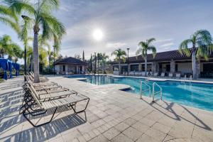 a swimming pool with lounge chairs and palm trees at Disney Area Vacation Rental with Game Room and Pool! in Davenport