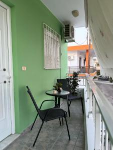 a table and chairs in a kitchen with green walls at The Sunlit Retreat in Kremasti