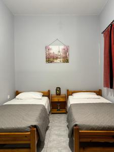 a bedroom with two beds and a picture on the wall at The Sunlit Retreat in Kremasti