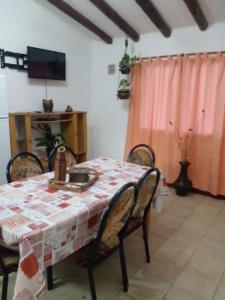 a dining room with a table and chairs and a television at La Soñada in Malargüe