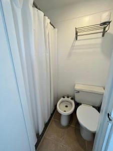 uma pequena casa de banho com um WC e uma cortina de chuveiro em ZAG Coliving Punta del este em Punta del Este