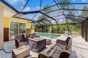 a conservatory with a table and chairs and a pool at #1 in North Port in North Port