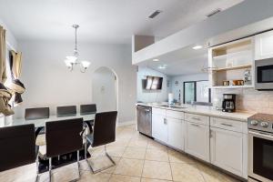 a kitchen with white cabinets and a table and chairs at #1 in North Port in North Port
