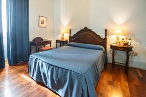 um quarto com uma cama e duas mesas e dois candeeiros em Hospedería Mirador de Llerena em Llerena