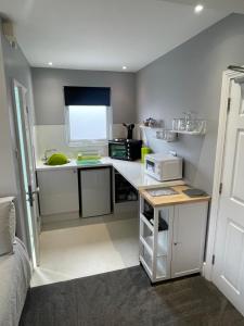 a small kitchen with a counter and a microwave at Rivendell Room Only Studios in Swanage