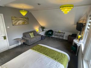 a bedroom with a bed and a couch and a table at Rivendell Room Only Studios in Swanage