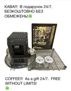 una macchinetta del caffè su un tavolo di vetro con due tazze di HotelGallery 21 a Lviv