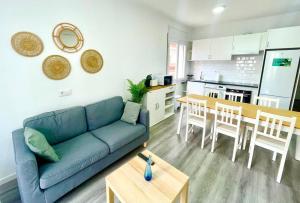 Una sala de estar con un sofá azul y una cocina. en SeaHomes Vacations - HEART OF TOSSA DE MAR, en Tossa de Mar