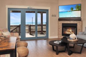 a living room with a fireplace with a view of the beach at The Blue Turtle by Pristine Properties Vacation Rentals in Mexico Beach +136 photos