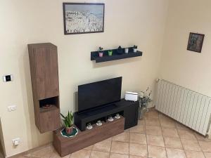 uma sala de estar com uma televisão de ecrã plano na parede em La vecchia vite casa vacanze em Trevi
