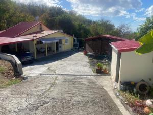 a house with a driveway next to a building at Entre Montagne et Mer in Vieux-Habitants