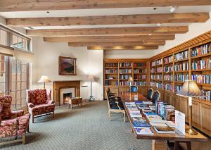 una biblioteca con una larga mesa con libros en Quail run, en Santa Fe