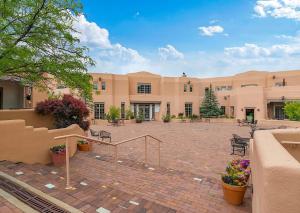 a building with a courtyard with chairs and flowers at Quail run in Santa Fe