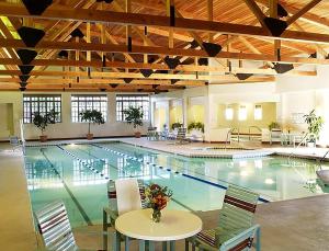 a large pool with tables and chairs in a building at Quail run in Santa Fe