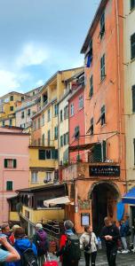 un grupo de personas caminando por una ciudad con edificios en Brezza Marina, en Riomaggiore