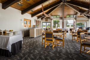 uma sala de jantar com mesas, cadeiras e janelas em Marsden Stay Rotorua em Rotorua