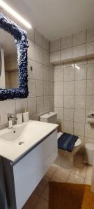 a bathroom with a sink and a toilet and a mirror at Melodia di Mare in Skala Kallirakhis
