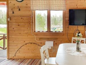 a wooden room with a table and a tv and a window at Holiday home GRÄSÖ II in Gräsö