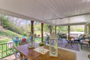 a screened porch with a wooden table with two lamps at Updated Marshall Home with Fire Pit and Game Room! in Marshall