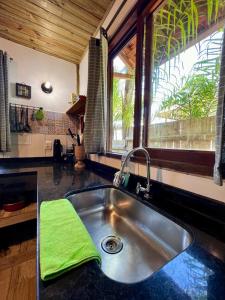 a kitchen sink with a green towel on the counter at Hospedagem Casa Maracujá in Trindade
