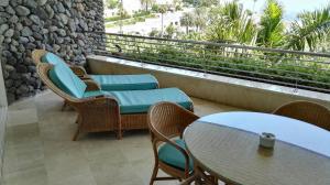 een patio met tafels en stoelen en een balkon bij Anfi Beach Club 29 Jul a 04 Ago in Las Palmas de Gran Canaria