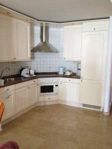uma cozinha com armários brancos e um forno com placa de fogão em Anfi Beach Club 29 Jul a 04 Ago em Las Palmas de Gran Canaria