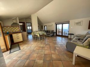 Il comprend un grand salon avec une cuisine et une table. dans l'établissement Appartamenti Pousada Michelino, à Parghelia