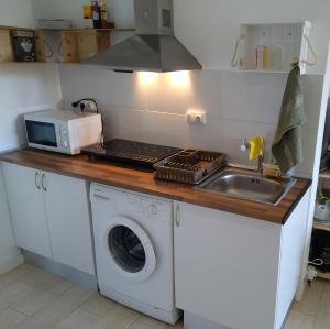 a kitchen with a washing machine and a microwave at Apartment on Carrer del Dr. Lluch in Valencia