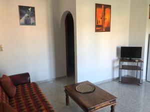 een woonkamer met een bank en een salontafel bij Blue Sky Apartments I in Makry Gialos