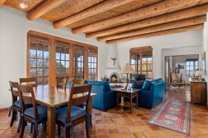 a living room with a wooden table and blue chairs at Quail run in Santa Fe