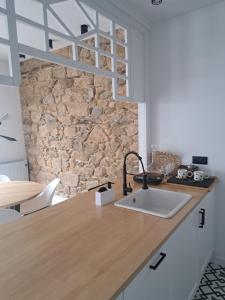 cocina con fregadero y pared de piedra en Piso nuevo-Plaza Armas, en Ferrol