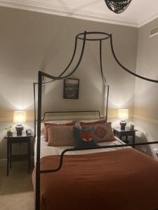 ein Schlafzimmer mit einem Himmelbett mit zwei Lampen in der Unterkunft The Beeches - Chatsworth Apartment No 2 - Sleeps 2 in Baslow