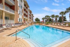 a swimming pool at a hotel with chairs and a building at Waterside Village Condo 302 by Pristine Properties Vacation Rentals in Mexico Beach