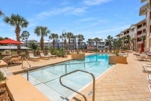 a pool at a resort with chairs and tables at Waterside Village Condo 302 in Mexico Beach