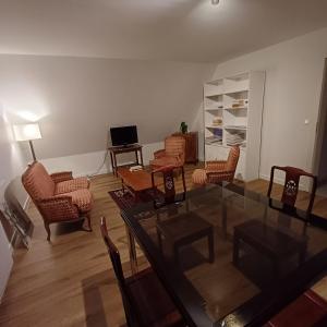 uma sala de estar com uma mesa de vidro e cadeiras em Les vignobles d'Alsace em Wintzenheim