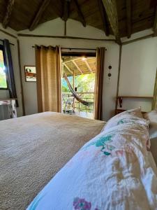 a bedroom with a bed and a large window at chalés frente à praia in Trindade +84 photos