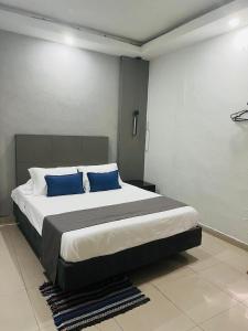 sypialnia z dużym łóżkiem z niebieskimi poduszkami w obiekcie Access Blue Cristal w mieście Monterrey