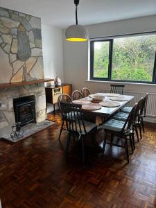 une salle à manger avec une table, des chaises et une cheminée dans l'établissement Teach Róise, à Dunfanaghy